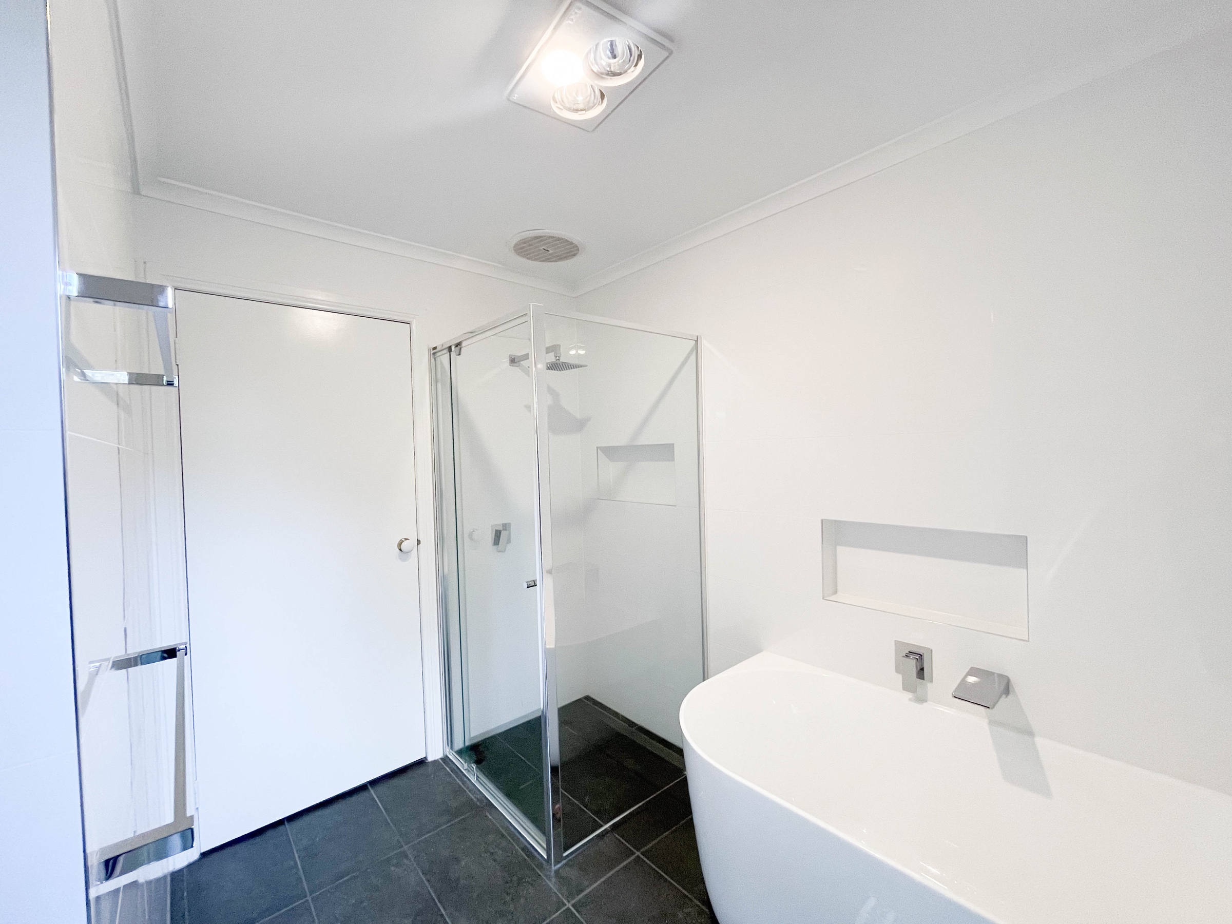 Completed Surrey Hills bathroom with freestanding bath, glass shower and recessed wall niches