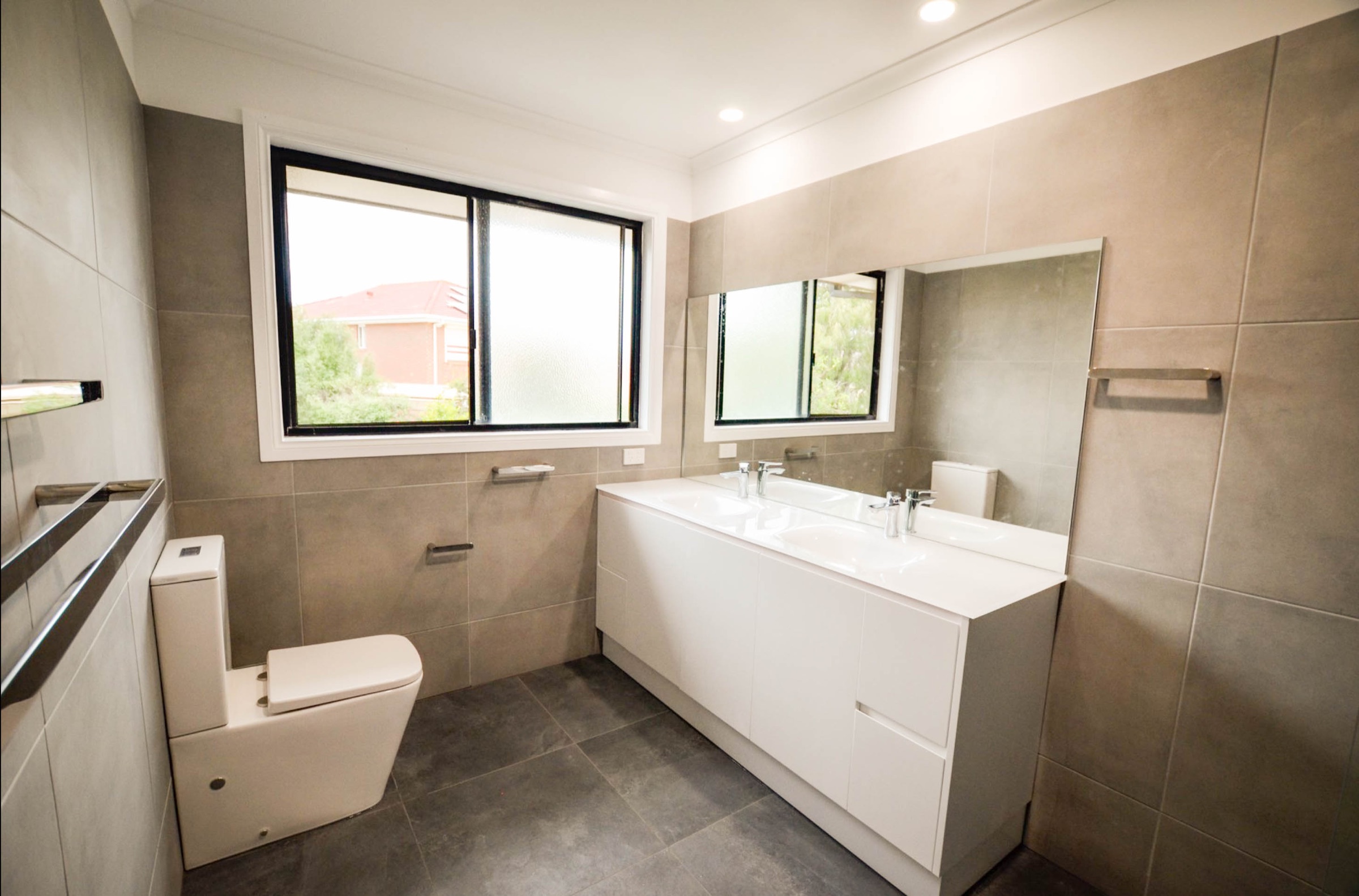 Completed bathroom with twin-basin vanity and frameless shower — Endeavour Hills
