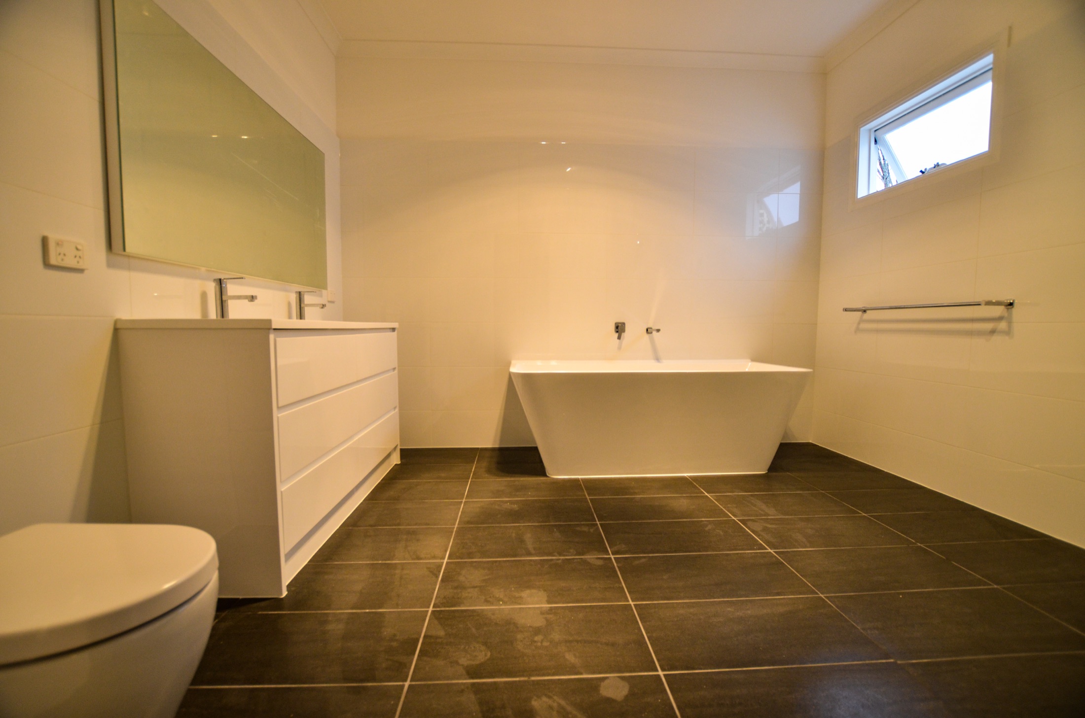 Completed enlarged bathroom with freestanding bath, double vanity and full-height tiling — Ivanhoe
