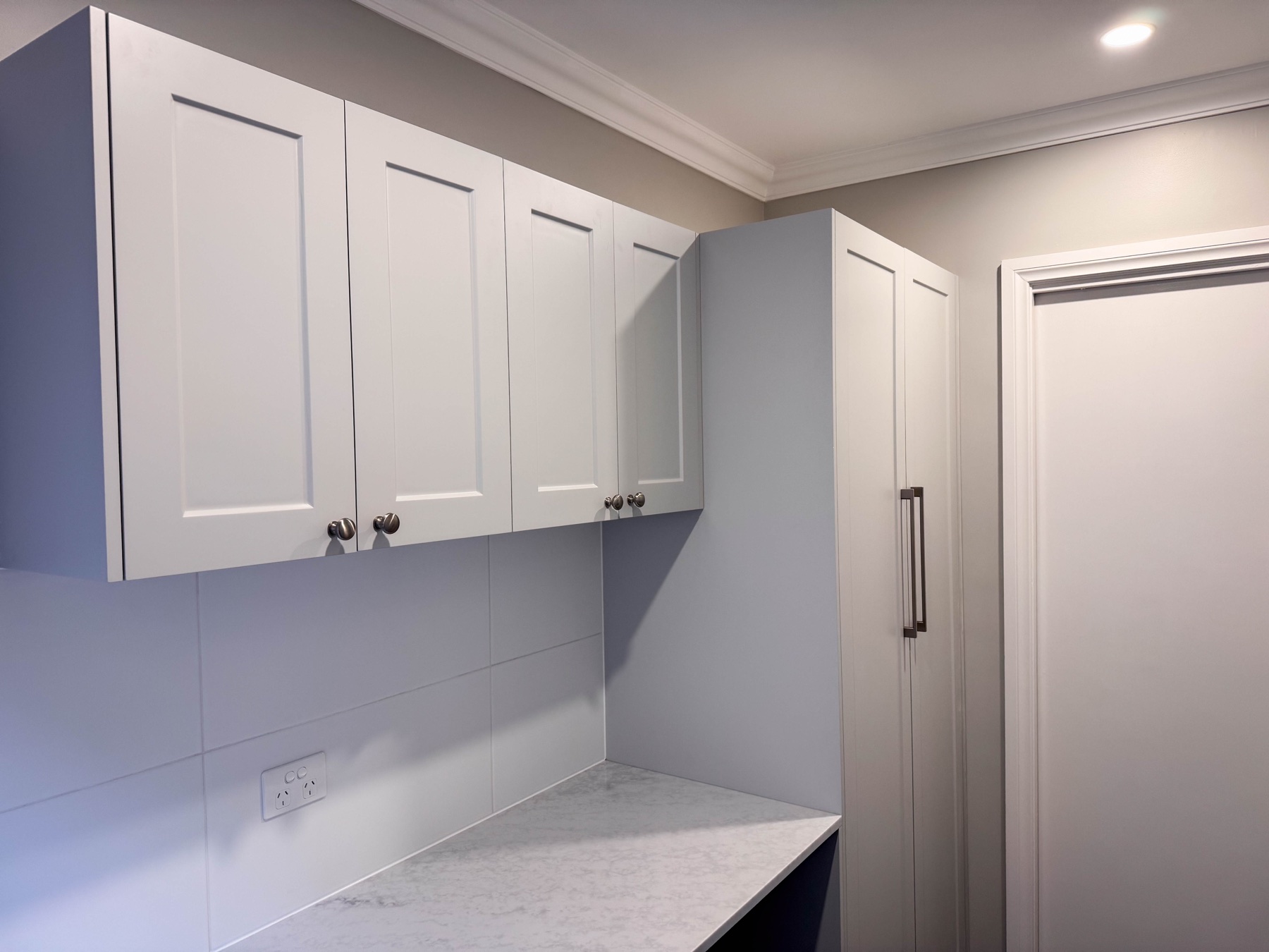 Completed overhead cabinetry and full-height storage