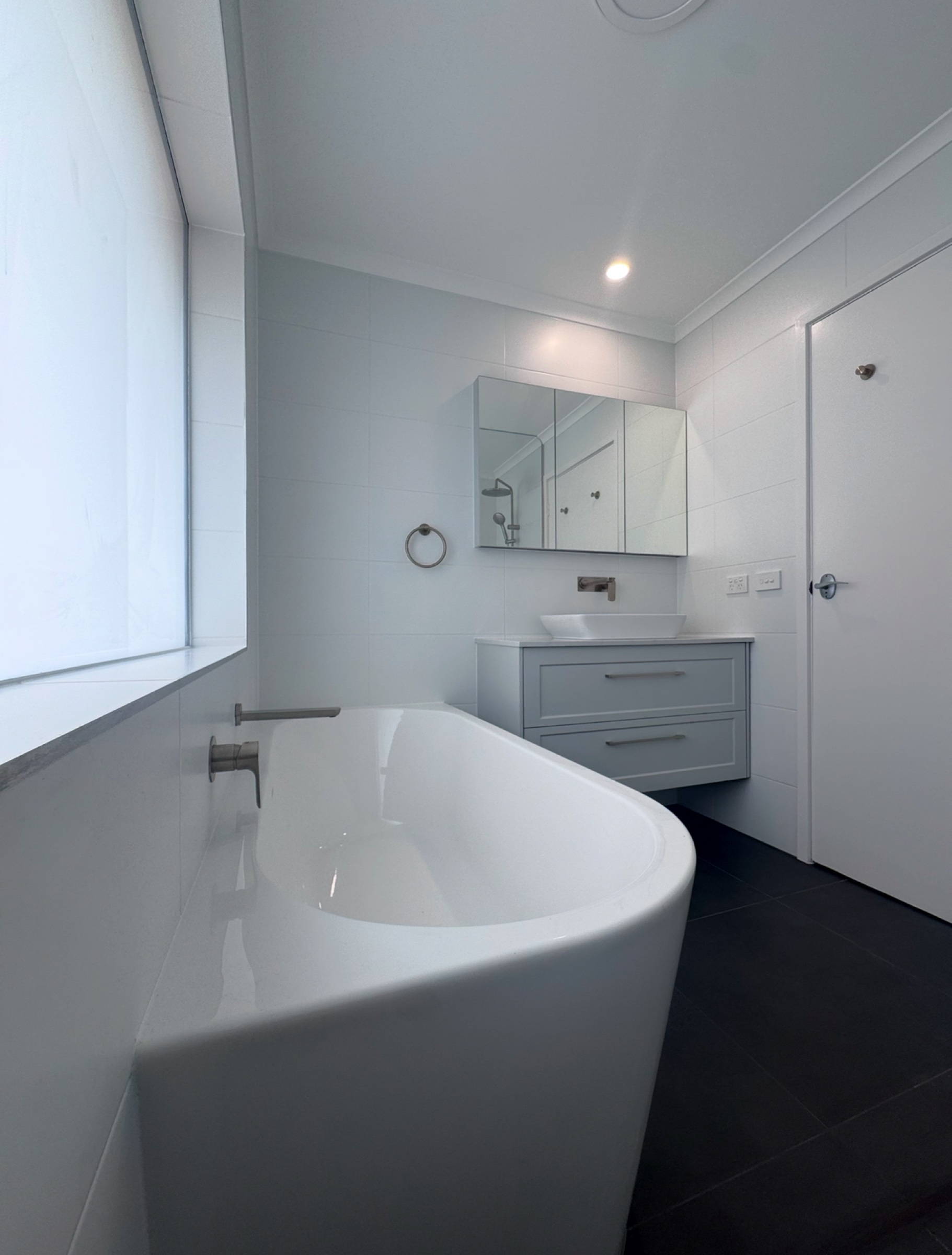 Completed upstairs family bathroom with freestanding bath, new window and wall-hung vanity