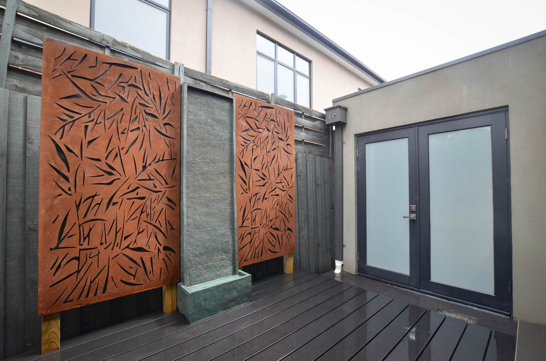 Completed composite decking and decorative feature screens around the courtyard water feature