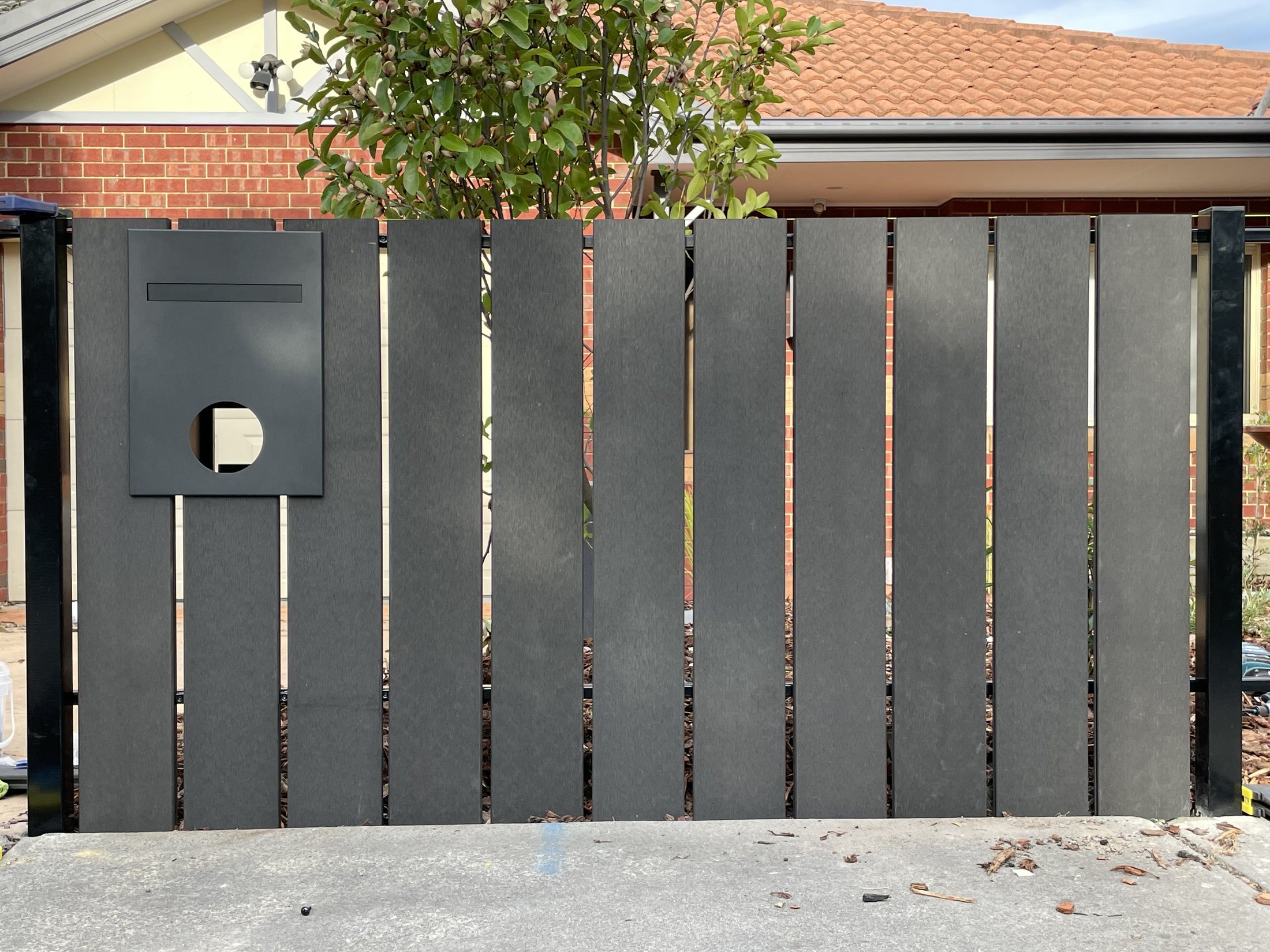 Completed charcoal composite front fence with integrated letterbox