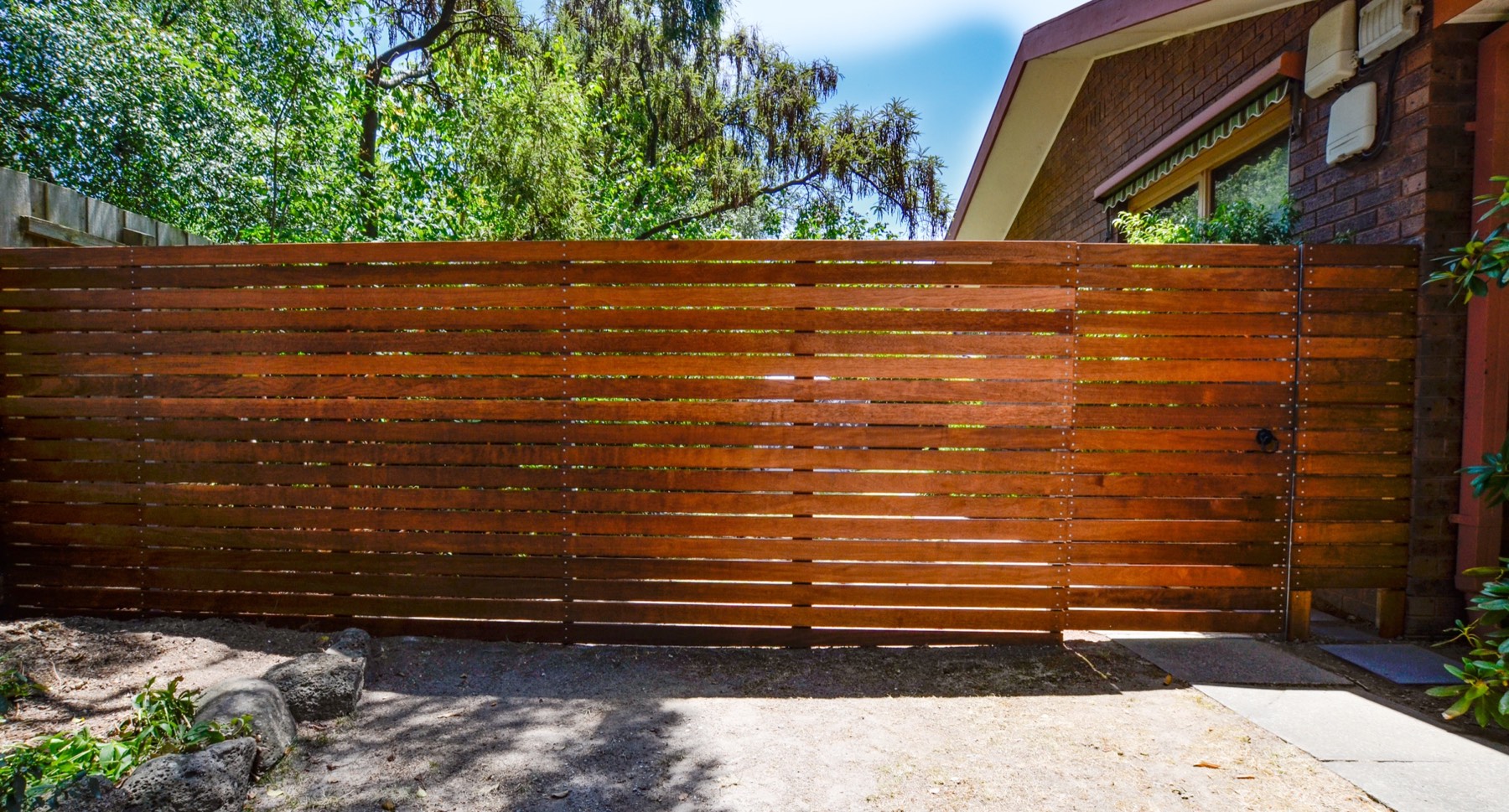Full-length Merbau privacy fence with integrated pedestrian gate