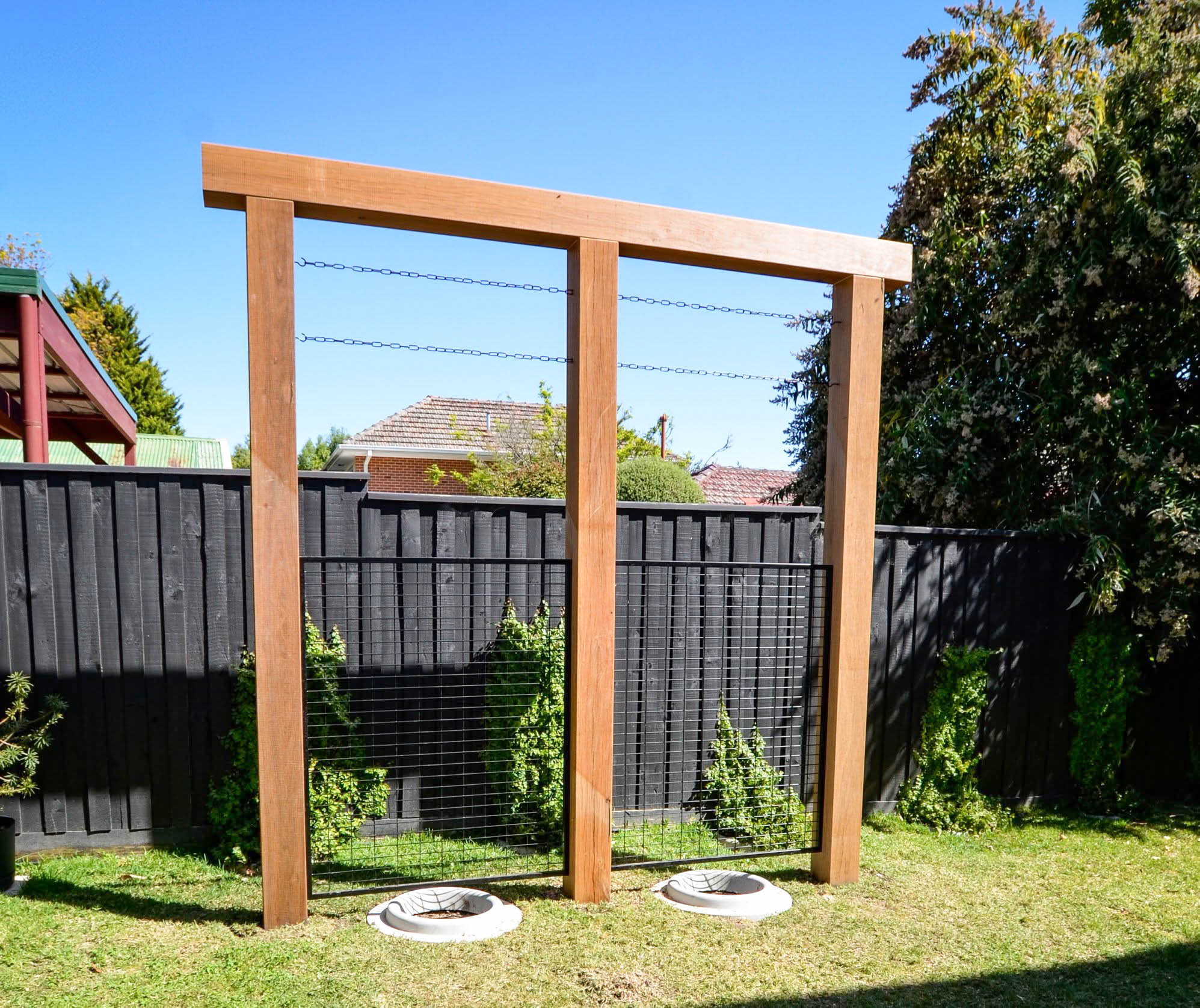 Completed heavy timber apple-tree support structure with two framed growing bays — Mont Albert