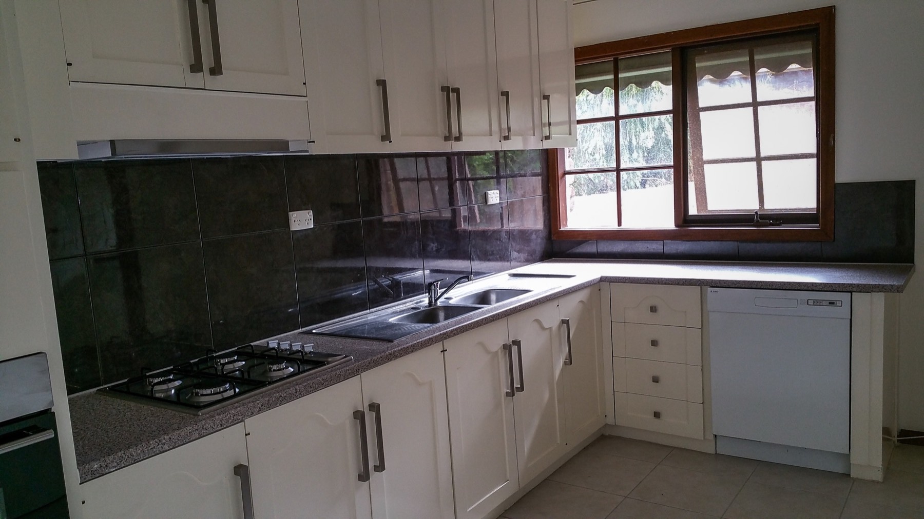 Completed rental kitchen with refreshed cabinetry, benchtops, appliances and tiled splashback
