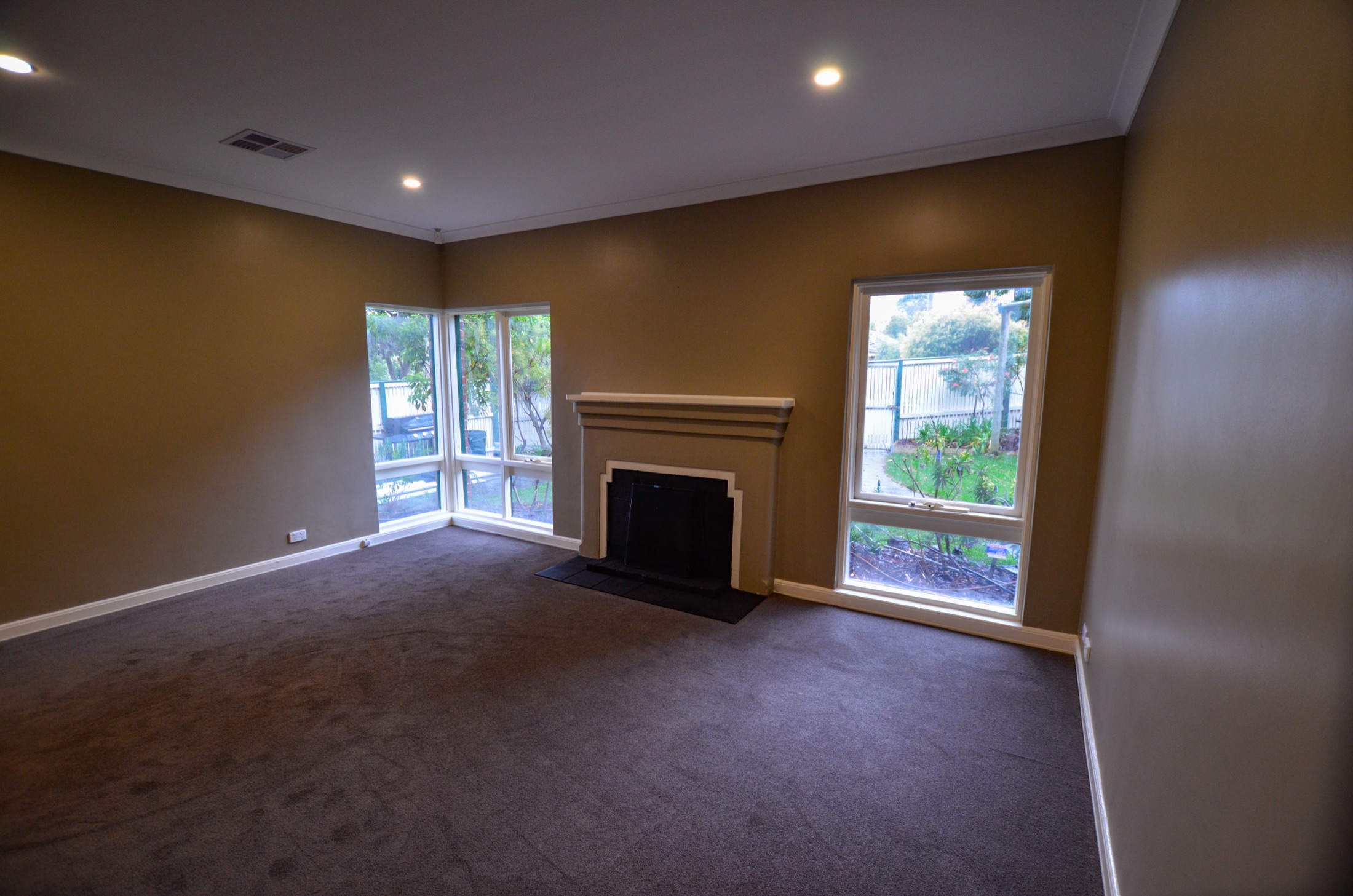 Completed living room with new carpet, lighting and restored fireplace
